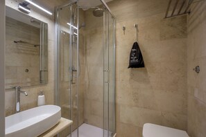 A modern bathroom with a glass shower enclosure, a white sink, and a toilet. - Daplace - Santa Susanna Suites (Rome)