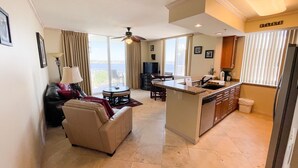 A spacious living area with a sofa, a dining table, and a kitchen island.