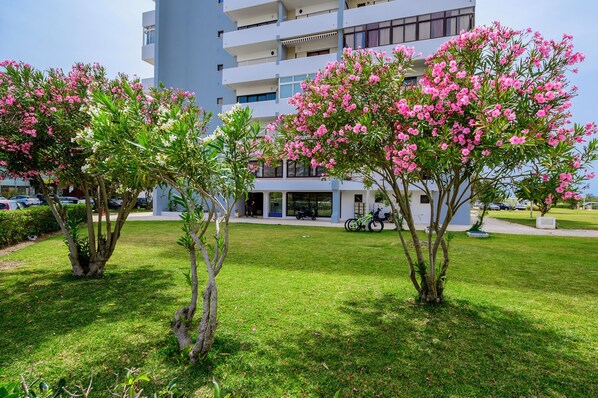 A modern building with a flat roof and multiple balconies.