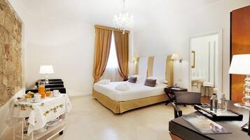Une chambre d’hôtel comprenant un lit, une table de chevet, une lampe et un bureau avec une chaise.