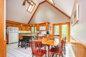 Una cocina con armarios de madera, una mesa de comedor y sillas.