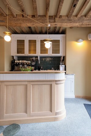 A kitchen with wooden cabinets, a central island, and hanging pendant lights.