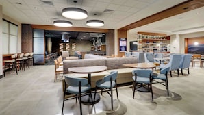 Un restaurante moderno con barra de cocina, zonas de estar y vistas a la ciudad.