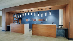 Una zona de recepción con mostradores de madera, pared azul e iluminación colgante.