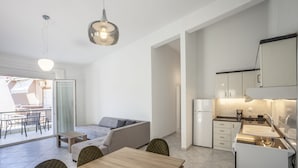 Un appartamento moderno con zona pranzo, divano, cucina e balcone.