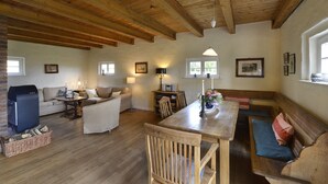 Un salón acogedor con techo de madera, un sofá, una mesa y una chimenea.