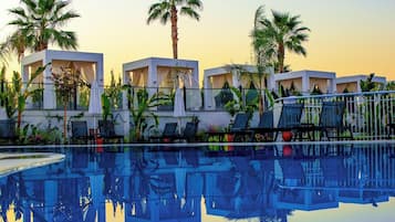 Una piscina al aire libre, camas de piscina gratis, sombrillas