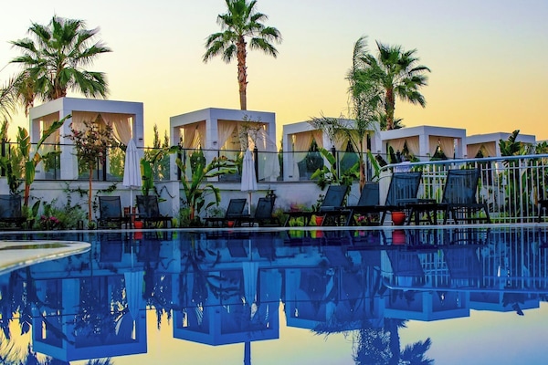 Una piscina al aire libre, camas de piscina gratis, sombrillas