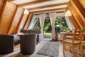 A cozy, wooden interior with a sofa, armchairs, and a dining table. - Holiday Home 'Ferienhäuser Am Waldschlößchen' with Mountain View, Private Terrace & Garden (Langelsheim)