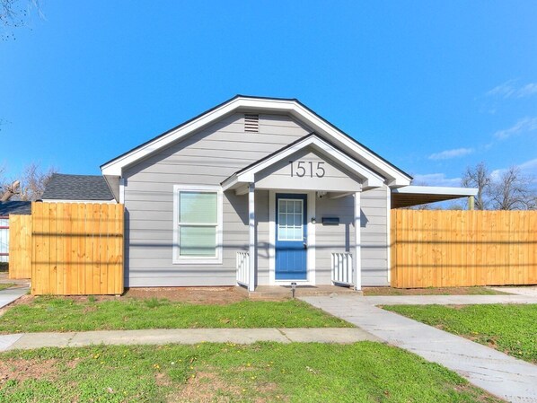 A single-story house with a blue front door and the number 1515 on the front.