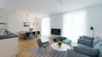 A modern living room with a sofa, a coffee table, and a TV.