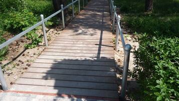 A wooden pathway leading to a beach with metal railings.