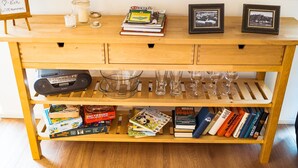 A wooden table with a sign, books, a magazine, candles, and framed photos. - Apartment 'Ferienwohnung Weitblick Koblenz' with Balcony and Wi-Fi (Koblenz)
