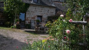 Una casa de piedra con jardín delantero.