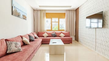 Apartamento superior, varias camas | Zona de estar | Una televisión de pantalla plana