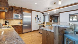 A modern kitchen with wooden cabinets, stainless steel appliances, and a granite countertop.