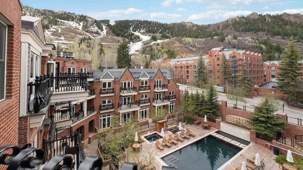 A hotel with a pool, outdoor seating, and a view of a mountainous landscape. - The Aspen Mountain Residences 45A - Studio Residence (Aspen)
