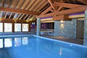 An indoor swimming pool with a wooden ceiling and stone walls. - 50m from ski slopes, 4th floor, swimming pool, sauna, hammam, balcony, parking, tv, ski locker, 32m² (Pralognan-la-Vanoise)