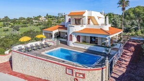 Une villa moderne dotée d’une piscine, d’un patio couvert et offrant une vue sur le paysage environnant.