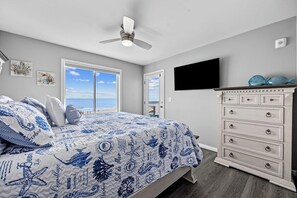 A bedroom with a bed, a dresser, a ceiling fan, a TV, and a view of the ocean. - 6 Beds, Pool, Corner View- 3 Bdrm Duneside Dream (North Myrtle Beach)