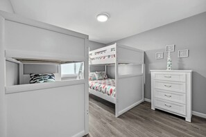 A bedroom with bunk beds, a dresser, and a window. - 6 Beds, Pool, Corner View- 3 Bdrm Duneside Dream (North Myrtle Beach)