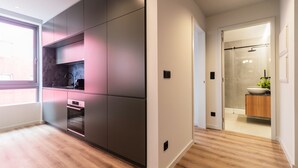 A modern kitchen with built-in appliances and a walk-in closet. - RUAH Q - Quiet Flat by LovelyStay (Vila Nova de Gaia)