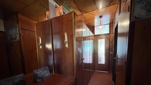 A compact room with a wooden bed, a dresser, and a door leading to another room. - 200 meters from the ski slopes, 3rd floor, balcony, TV, ski locker, 50 m², Pra Loup (Uvernet-Fours)