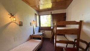 A dormitory room with bunk beds, a desk, and a chair. - 200 meters from the ski slopes, 3rd floor, balcony, TV, ski locker, 50 m², Pra Loup (Uvernet-Fours)
