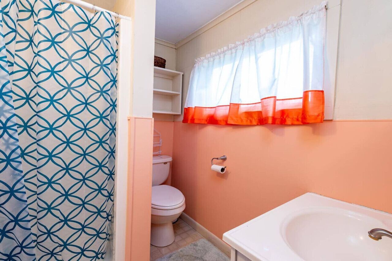A bathroom with a toilet, a sink, and a shower curtain with a geometric pattern.