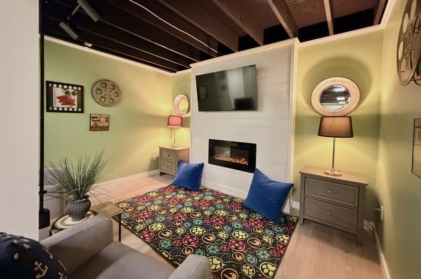 Un dormitorio con cama, televisión, chimenea y espejo.