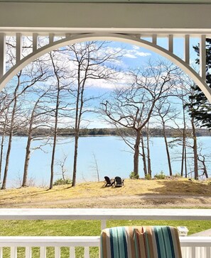 Un portico coperto con vista su un lago e alberi.