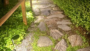 A stone pathway leading to a building with a wooden fence on one side. - Mere Point Sunrise Views at Eastern Shore! (Brunswick)