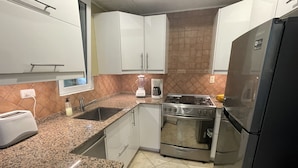 A kitchen with white cabinets, a granite countertop, a stove, a refrigerator, and a sink. - 2 bedrooms with pool. Walking distance to Cabarete beach, restaurants, shops. (Cabarete)