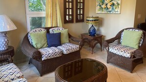 A living room with wicker furniture, a glass coffee table, and a painting on the wall. - 2 bedrooms with pool. Walking distance to Cabarete beach, restaurants, shops. (Cabarete)