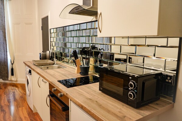 A modern kitchen with a built-in microwave, a sink, and a dishwasher.