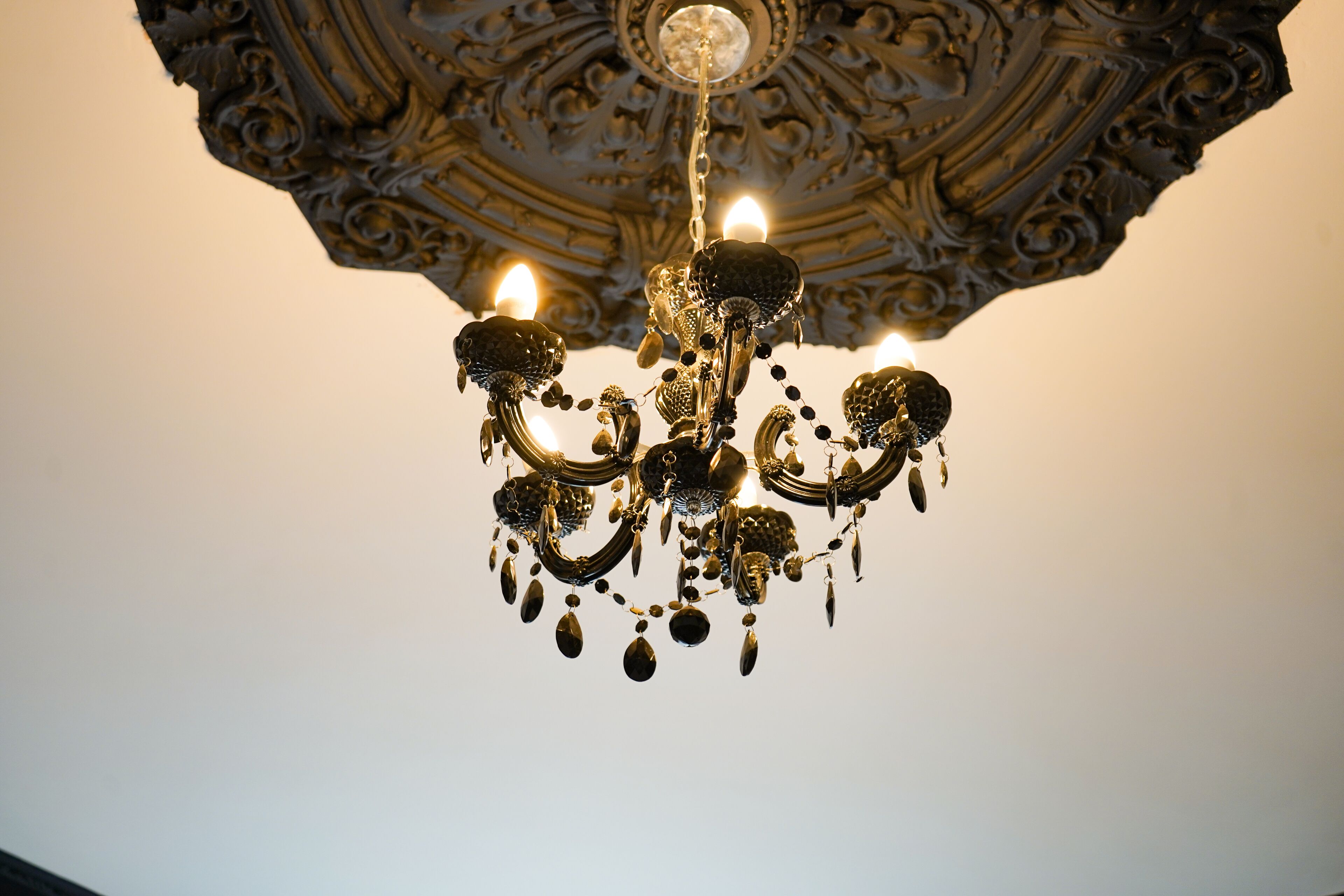 Un lustre à plusieurs bras, orné de décorations suspendues.