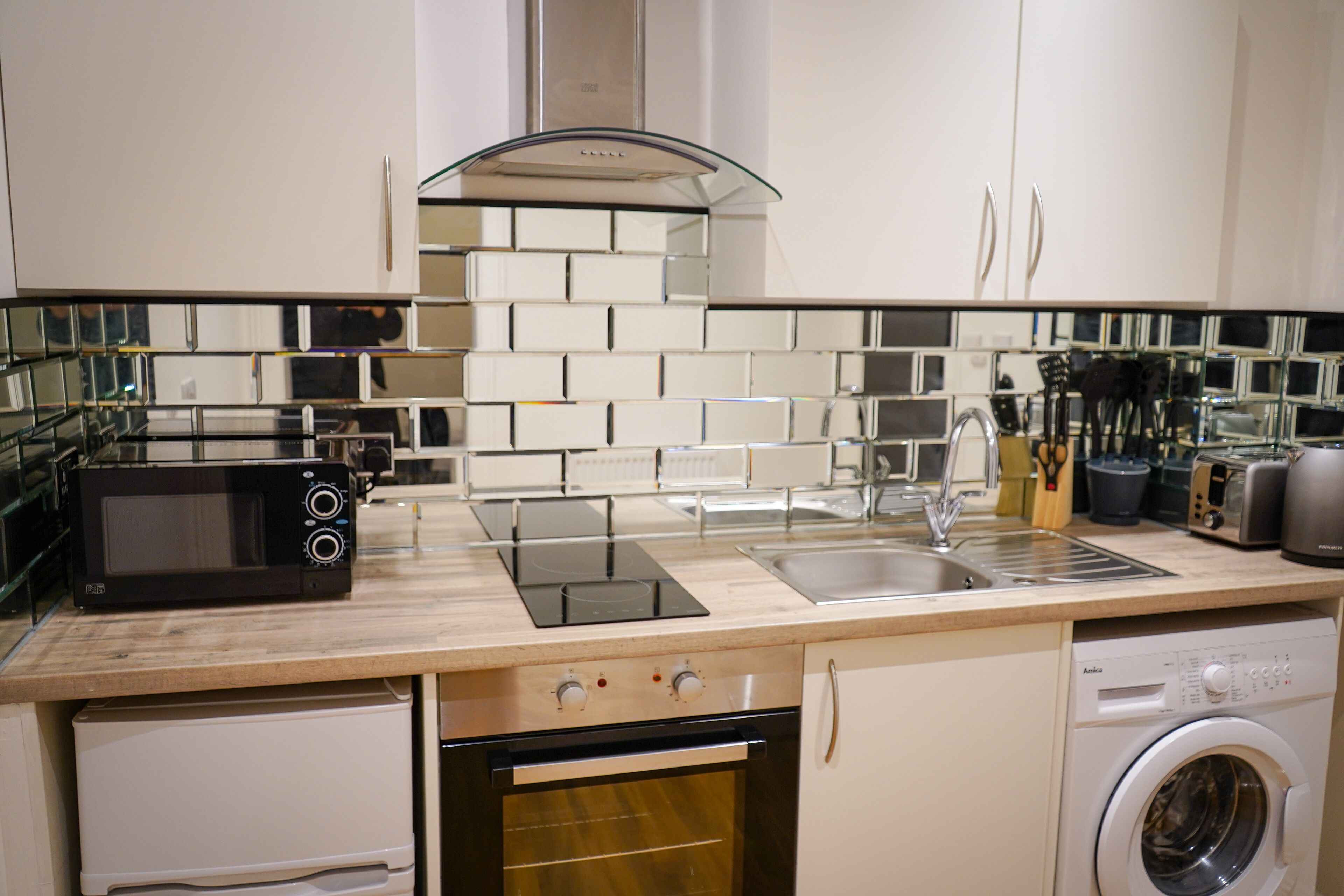 A modern kitchen with a microwave, oven, sink, and dishwasher.