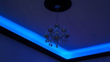 A chandelier with multiple arms and hanging crystals, suspended from a ceiling with a circular light fixture.