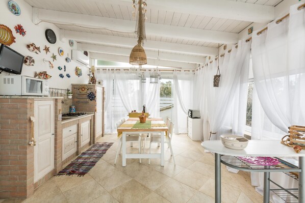 A kitchen with white cabinets, a microwave, a stove, and a dining table with chairs.