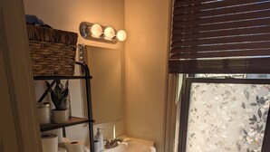 A compact bathroom with a toilet, sink, and window. - Hidden Gem in Cortland (Cortland)