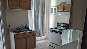 A compact kitchen with wooden cabinets, a gas stove, and a sink. - Hidden Gem in Cortland (Cortland)
