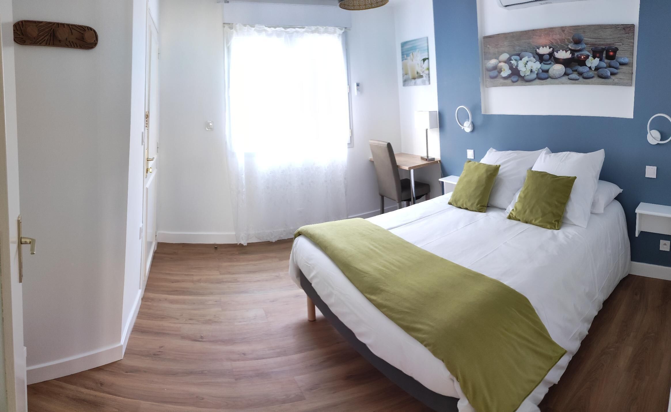A bedroom with a bed, a desk, and a chair.
