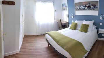A bedroom with a bed, a desk, and a chair.