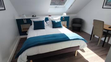 Un dormitorio moderno con cama, mesitas de noche, un escritorio y una silla.