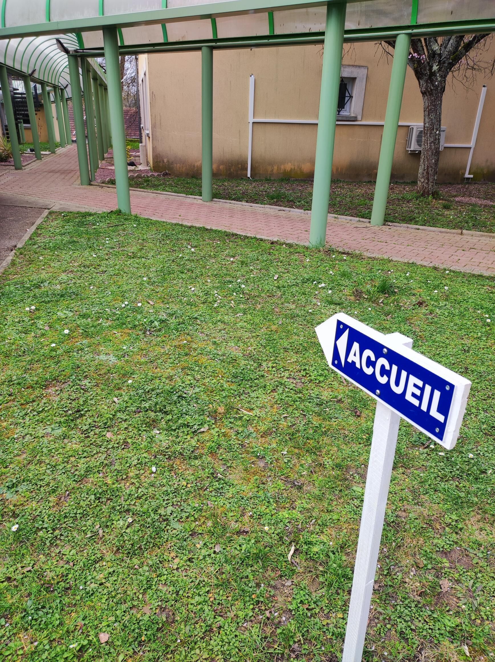 Een bord met de tekst 'ACCUEIL', wat een ontvangstgebied aangeeft, mogelijk de entree van een hotel.