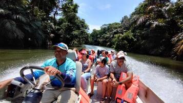 A boat tour with passengers wearing life jackets.
