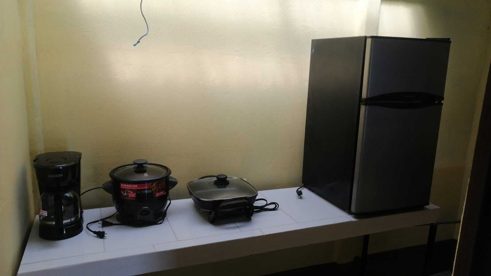 A kitchen counter with a coffee maker, a slow cooker, and a toaster.