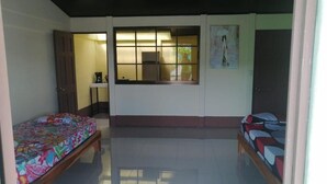 A room with two beds, a window, and a door. - Cabinas Lawson (Puerto Jiménez)