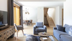 A modern living room with a sofa, armchairs, a coffee table, and a TV on a wooden cabinet. - TERRESENS - Les Edelweiss (Vaujany)