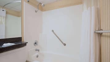 Un baño con bañera, inodoro y espejo.